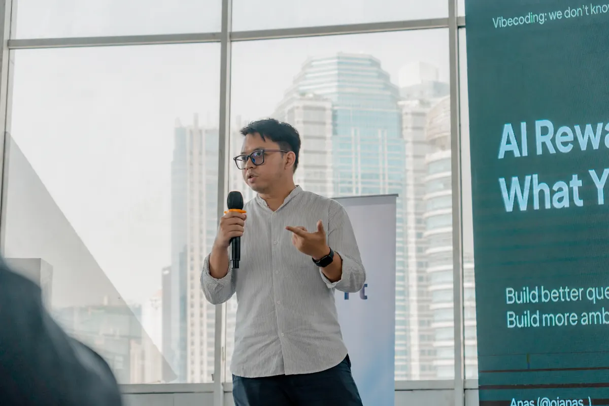 Anas menjelaskan materi AI Rewards What You Know sambil memegang mikrofon